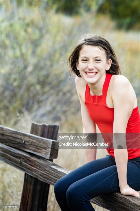 Femme Énergique Préadolescente Sasseyant Sur Un Portrait De Clôture Regardant Lappareilphoto