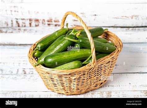 Fresh cucumber in a wicker basket over wooden background. Cucumber ...