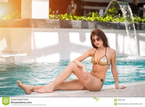 Frau Im Bikini Der Durch Den Swimmingpool Sitzt Stockfoto Bild Von