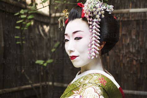 A Woman Dressed In The Traditional Geisha Style Wearing A Kimono And