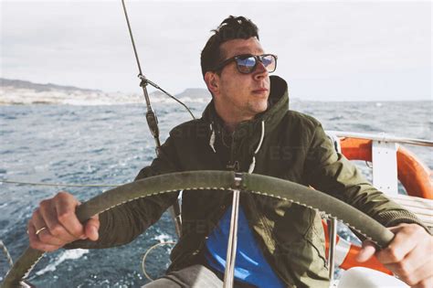 Young Man Driving Boat On Sea Stock Photo