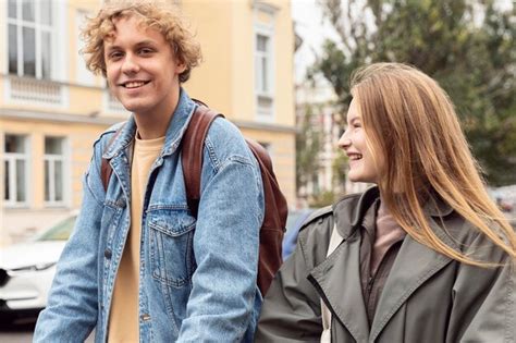 Casal sorridente ao ar livre na cidade em scooters elétricos Foto Grátis