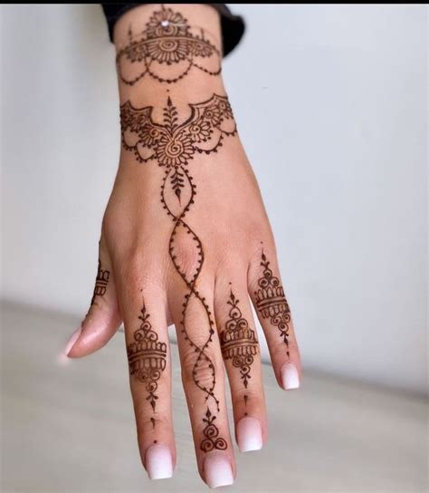 A Woman S Hand With Henna Tattoos On It