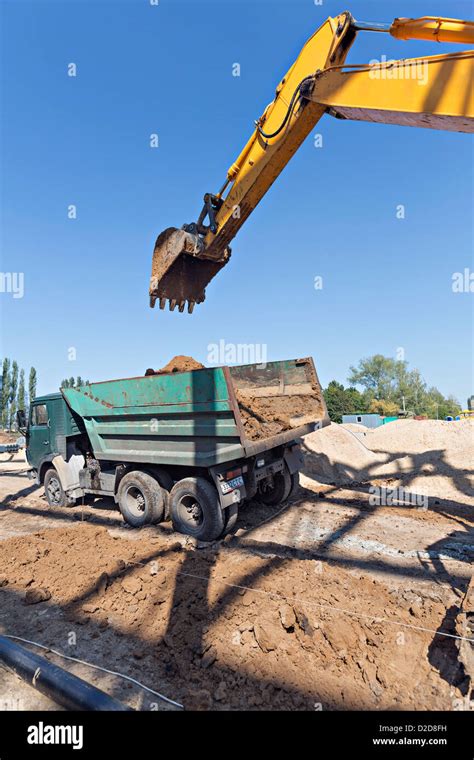 Digger Loading Soil Onto Dumper Truck Stock Photo Alamy