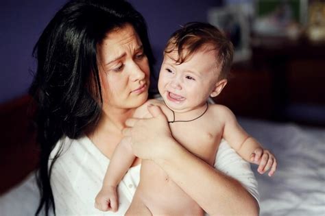 Premium Photo Beautiful Woman Calms Sad Cute Baby At Home Cute Naked Boy Crying In His Mother