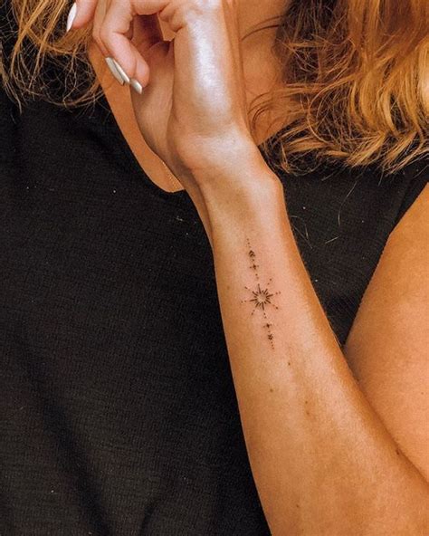 A Woman With A Small Star Tattoo On Her Arm