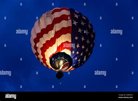 Illuminated Stars And Stripes Hot Air Balloon Flying During Dawn Patrol