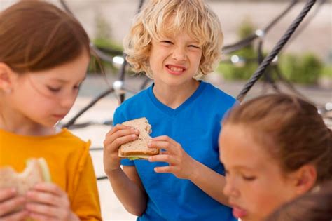 Fermez Les Enfants Mangeant Des Sandwichs Ensemble Photo Gratuite