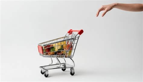 Premium Photo Hand Holding Shopping Cart Full Of Fresh Vegetables