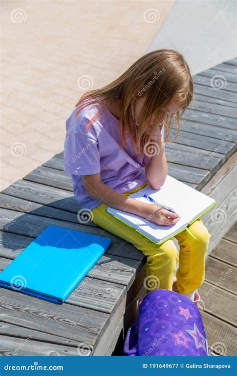 Colegiala Sentada En Un Banco En El Parque Público Y Haciendo Notas En Su Libro De Notas Imagen