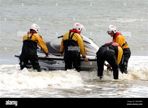 A Lifeboat Rnli Crew Members Launching A Small Inshore Rescue Boat Jet