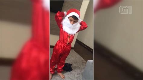 Vídeo Menino de 4 anos se veste de Papai Noel e distribui balas no