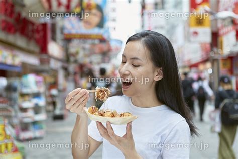 大阪でたこ焼きを食べる日本人女性の写真素材 129303292 イメージマート