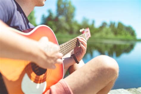 Musician Playing Acoustic Guitar In Nature On Summer Vacation Stock