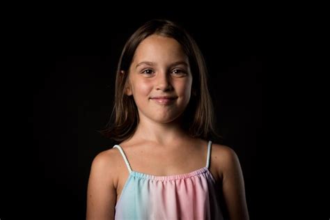 Premium Photo Portrait Of Smiling Girl Standing Against Black Background