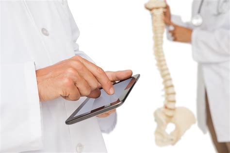 Premium Photo Mid Section Of Doctors With Digital Table And Skeleton