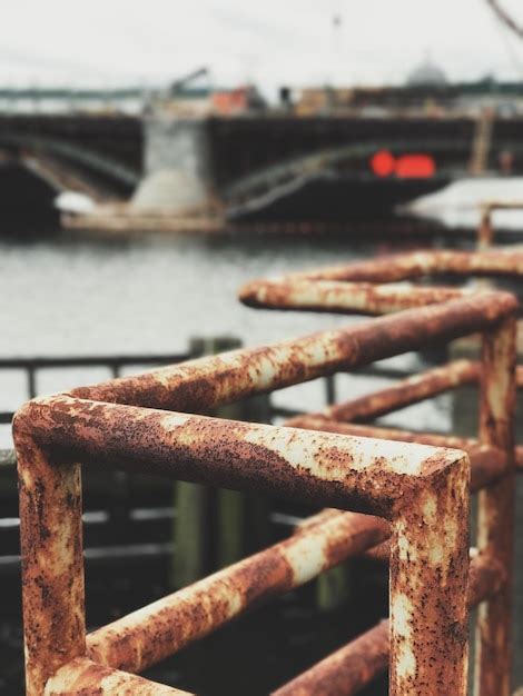 Premium Photo Close Up Of Rusty Railing Against Bridge Over River