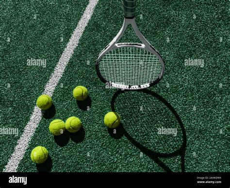 Tennis Court Top View Six Tennis Balls And Racket On The Green Grass