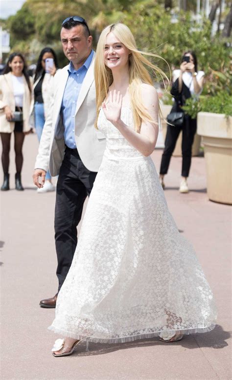 Elle Fanning In A White Dress Leaves Hotel Martinez During The 76th Annual Cannes Film Festival