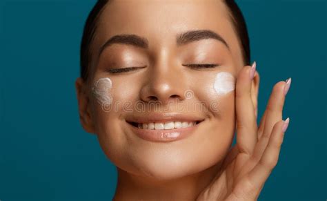 Close Up Beauty Portrait Of A Beautiful Young Woman Applying Face Cream