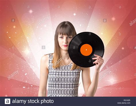 Young Lady Holding Vinyl Record On A Red Background With Lights Shining