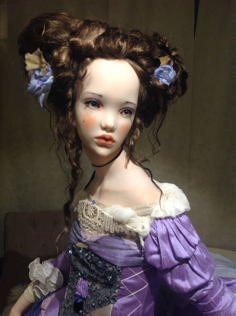 A Doll With Long Hair Wearing A Purple Dress