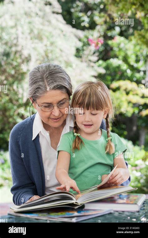 Grandmother Reading To Granddaughter Outdoors Stock Photo Alamy