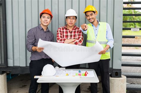 Ingeniero Y Equipo De Construcción Sujetando Planos a Mano Y Señalando