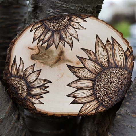 A Wooden Slice With Sunflowers Painted On It Sitting In Front Of A Tree