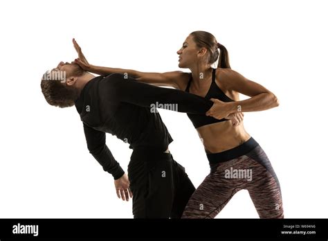 Man In Black Outfit And Athletic Caucasian Woman Fighting On White