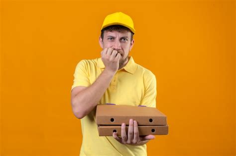 Free Photo Delivery Man In Yellow Polo Shirt And Cap Holding Pizza