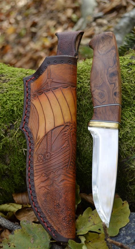 A Knife And Sheath Sitting Next To Each Other On Some Moss Covered