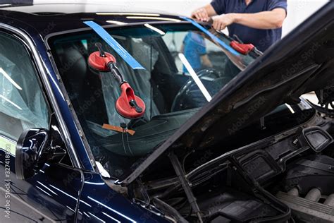 Service workers replacing car front windshield. Stock Photo | Adobe Stock