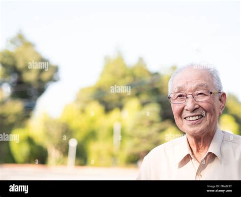 An elderly Asian man smiling happily outside Stock Photo - Alamy