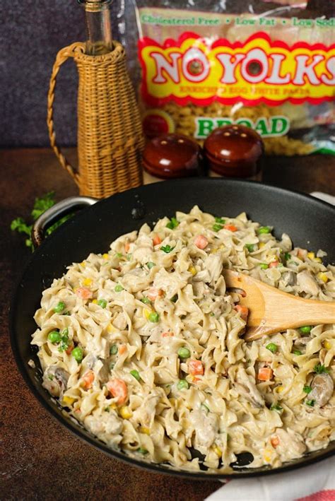 A Skillet Filled With Pasta And Vegetables Next To A Bag Of Noodle Noodles