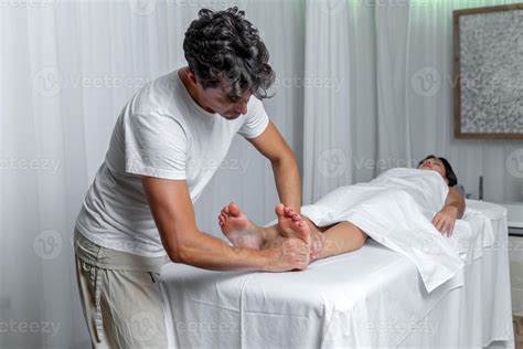 Male Masseur Applying Pressure To Foot Of Woman In Reflexology Massage At Spa 19986970 Stock