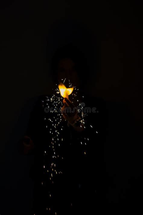 Hand Holding a Flame in the Dark. Magic Trick. Sparks of Fire on Black Background Stock Photo ...