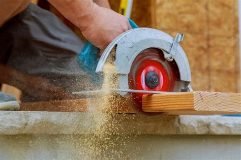 Premium Photo Close Up Of A Carpenter Using A Circular Saw To Cut A