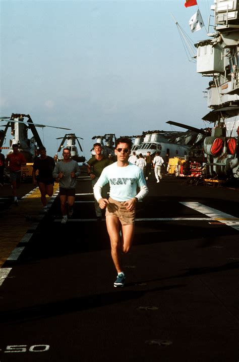 Crewmen And Marines Run On The Flight Deck Of The Amphibious Assault