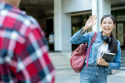 Beautiful student woman with backpack and books outdoor is greeting ...