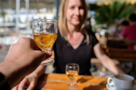 Premium Photo Cropped Hand Of Friend Holding Whiskey Glass Against