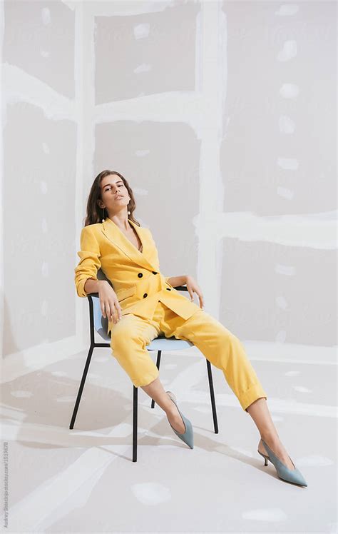 Young Female Fashion Model In Abstract White Space With Yellow Outfit