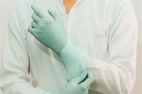 Latin American Female Doctor In White Coat Putting On Gloves Stock