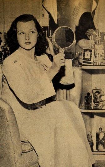 An Old Black And White Photo Of A Woman Holding A Magnifying Glass