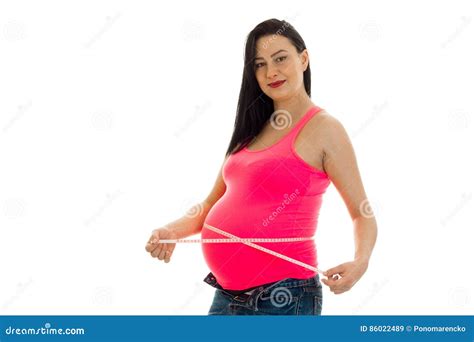 Beautiful Young Pregnant Brunette Woman Touching Her Belly Posing With Measure Tape And Looking