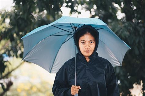 Premium Photo Portrait Of Woman Wearing Raincoat Holding Umbrella