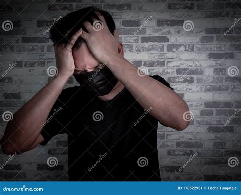 Asian Man Wearing Black Protective Face Mask And Black Shirt On Dark