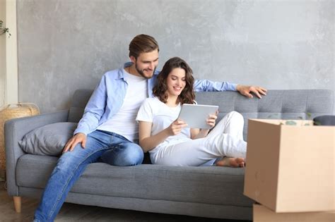 Premium Photo Happy Couple Sitting And Planning New Home Decoration At Home With A Tablet At