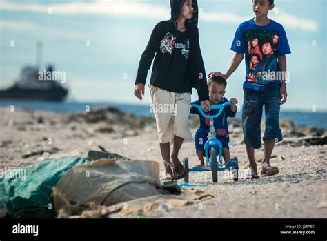 Children having leisure time on Cilincing beach, North Jakarta, Jakarta, Indonesia, with Jakarta ...