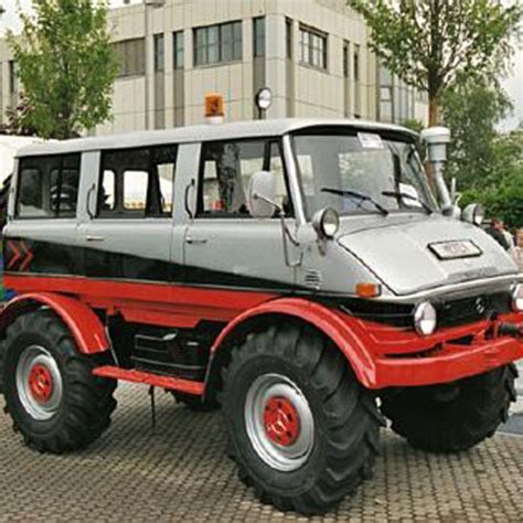 An Old Style Bus Is Parked In Front Of A Building With People Standing